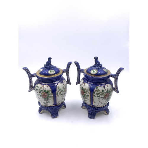 347 - A pair of Oriental hand painted porcelain twin handled ginger jars and covers - approx. 21cm high