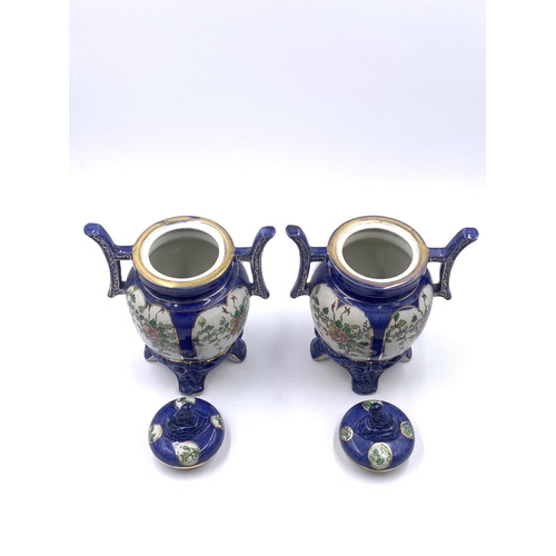 347 - A pair of Oriental hand painted porcelain twin handled ginger jars and covers - approx. 21cm high