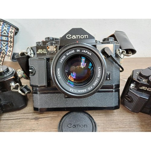 615 - Five Canon A-1 35mm SLR cameras fitted with Canon FD lenses, one 1:1.4 50mm, Power Winder A and Data... 