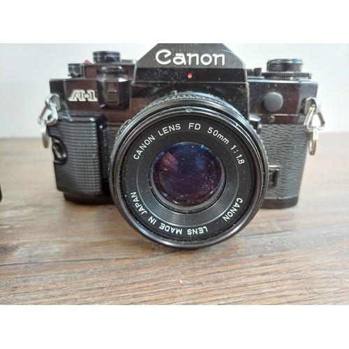 615 - Five Canon A-1 35mm SLR cameras fitted with Canon FD lenses, one 1:1.4 50mm, Power Winder A and Data... 