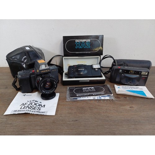 644 - Three 35mm cameras, one boxed Olympus XA2 compact fitted with A11 flash with instruction manual, one... 