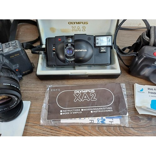 644 - Three 35mm cameras, one boxed Olympus XA2 compact fitted with A11 flash with instruction manual, one... 