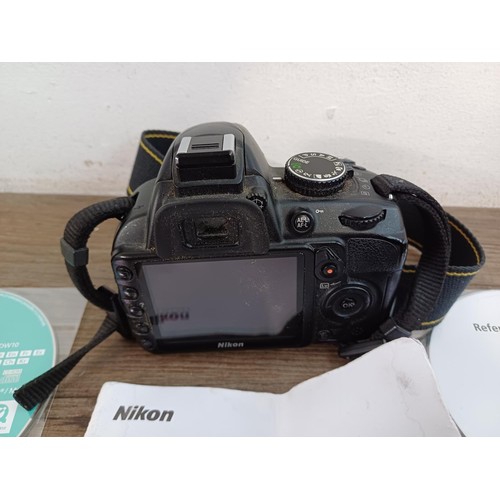 647 - A Nikon D3100 DSLR camera body with charger, software discs and instruction manual