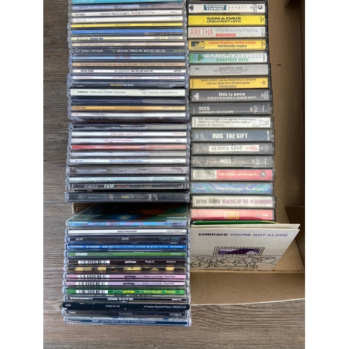 739 - Two Boxes containing CDs and cassettes by a variety of artists and bands to include Oasis, R.E.M, Bo... 