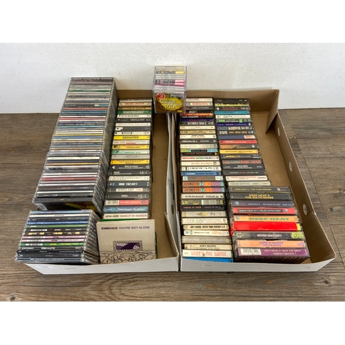 739 - Two Boxes containing CDs and cassettes by a variety of artists and bands to include Oasis, R.E.M, Bo... 