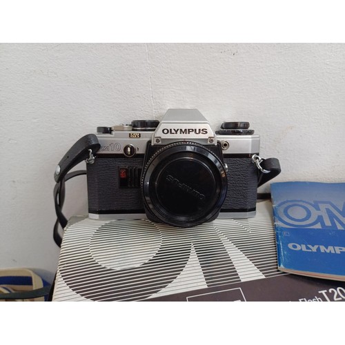 667 - A collection of Olympus items to include five OM10 35mm SLR cameras, Zuiko lenses, flashes etc.