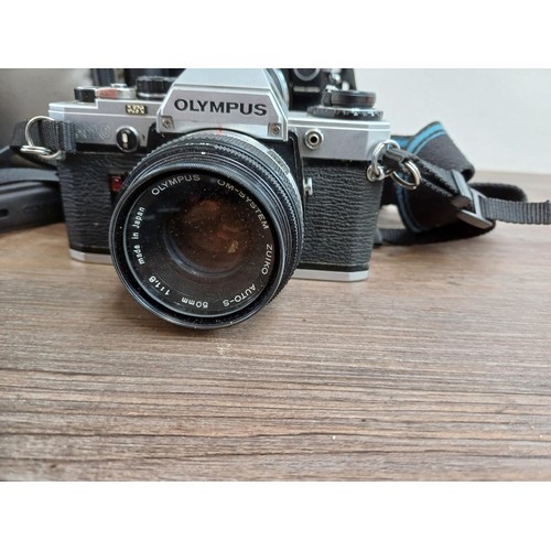 667 - A collection of Olympus items to include five OM10 35mm SLR cameras, Zuiko lenses, flashes etc.