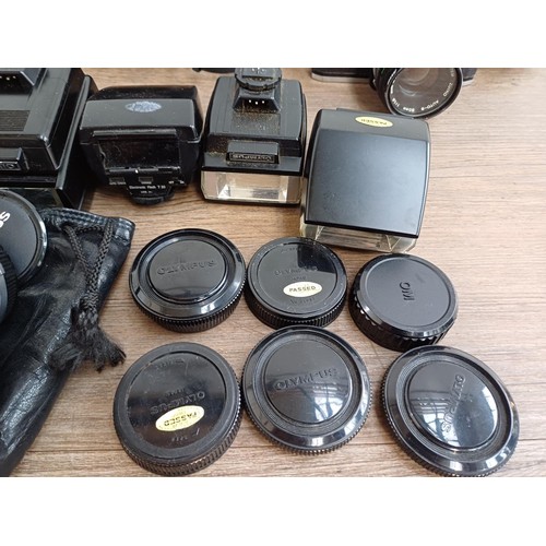 667 - A collection of Olympus items to include five OM10 35mm SLR cameras, Zuiko lenses, flashes etc.