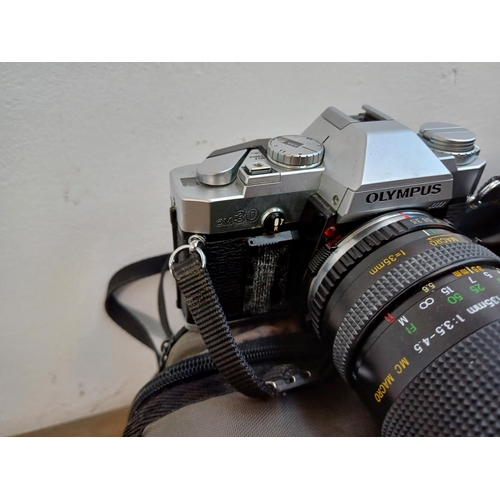 675 - Five Olympus 35mm SLR cameras, one OM30 with instruction manual, three OM40 Program and one OM101 Po... 