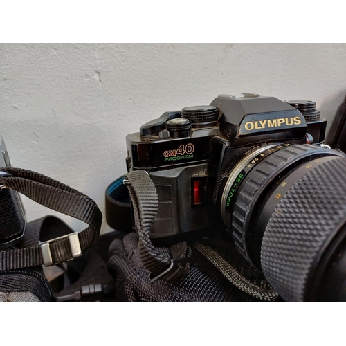 675 - Five Olympus 35mm SLR cameras, one OM30 with instruction manual, three OM40 Program and one OM101 Po... 