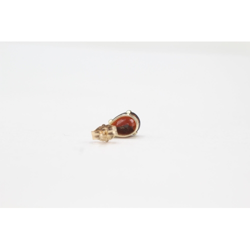 2110 - A pair of 9ct gold garnet stud earrings - approx. gross weight 0.9g