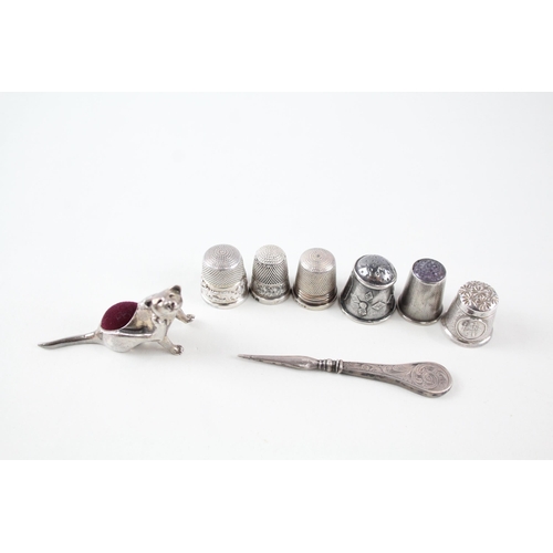 2297 - Eight .925 silver sewing accessories to include six thimbles, novelty pin cushion etc. - approx. gro... 