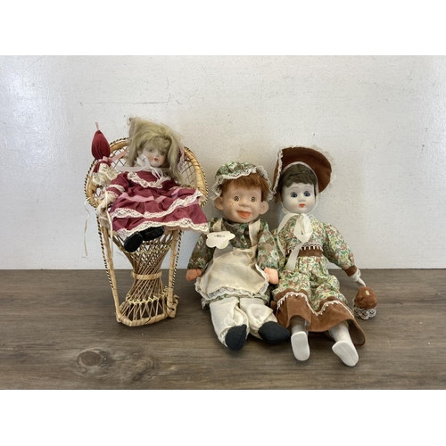 433 - Three porcelain headed dolls together with 1970s style wicker peacock chair