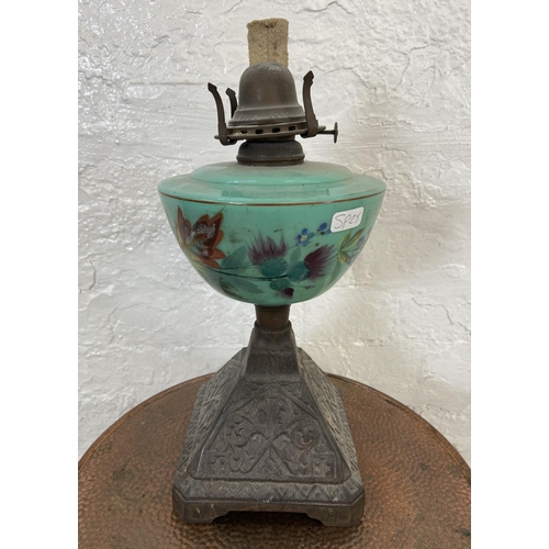 16 - Two items, one Victorian cast metal oil lamp with hand painted green glass reservoir - approx. 33cm ... 