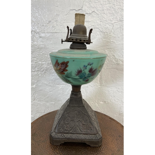 16 - Two items, one Victorian cast metal oil lamp with hand painted green glass reservoir - approx. 33cm ... 