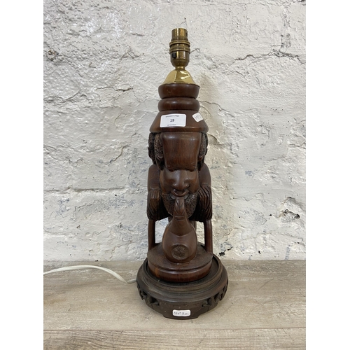 19 - An African carved hardwood figural table lamp on circular base - approx. 43cm high