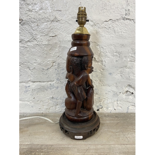 19 - An African carved hardwood figural table lamp on circular base - approx. 43cm high