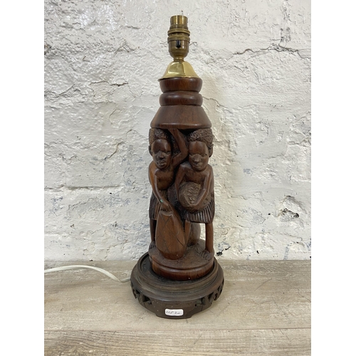 19 - An African carved hardwood figural table lamp on circular base - approx. 43cm high