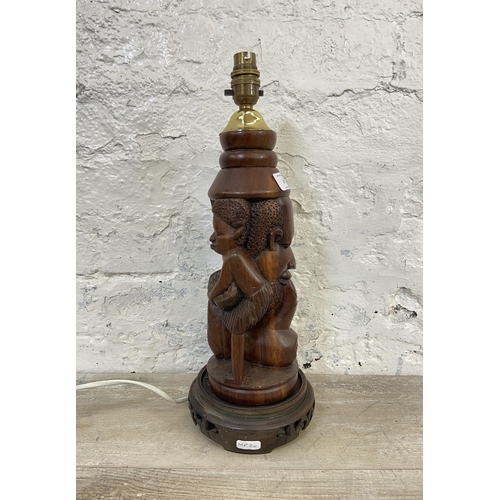 19 - An African carved hardwood figural table lamp on circular base - approx. 43cm high