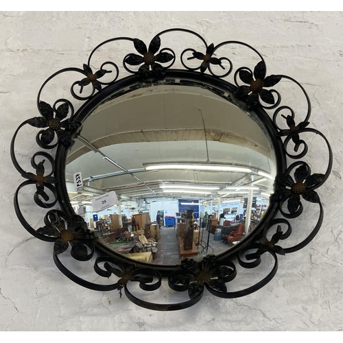 29 - A black painted wrought metal floral framed circular wall mirror - approx. 46cm diameter