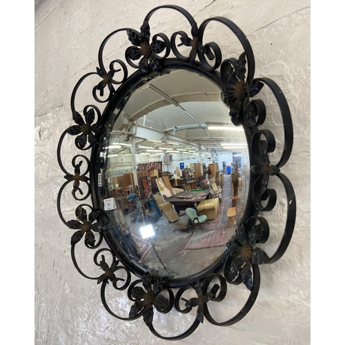 29 - A black painted wrought metal floral framed circular wall mirror - approx. 46cm diameter