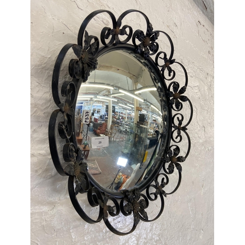 29 - A black painted wrought metal floral framed circular wall mirror - approx. 46cm diameter