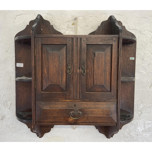 32 - An Arts & Crafts oak wall hanging two door smoker's cabinet - approx. 70cm high x 68cm wide