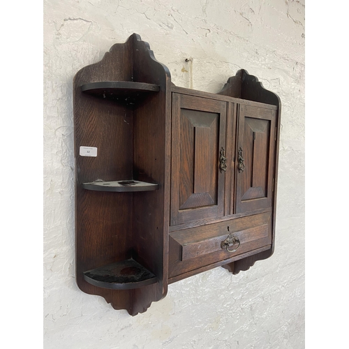 32 - An Arts & Crafts oak wall hanging two door smoker's cabinet - approx. 70cm high x 68cm wide