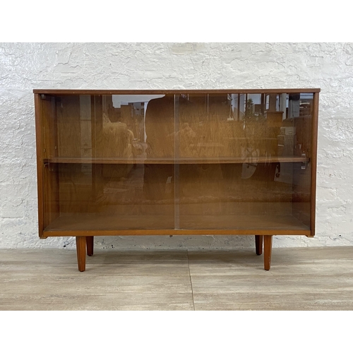 42 - A mid 20th century Avalon teak bookcase with two glass sliding doors - approx. 76cm high x 114cm wid... 