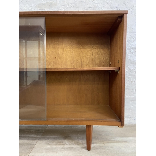 42 - A mid 20th century Avalon teak bookcase with two glass sliding doors - approx. 76cm high x 114cm wid... 