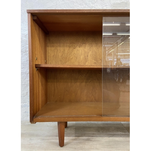 42 - A mid 20th century Avalon teak bookcase with two glass sliding doors - approx. 76cm high x 114cm wid... 