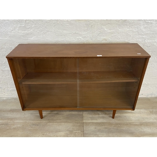 42 - A mid 20th century Avalon teak bookcase with two glass sliding doors - approx. 76cm high x 114cm wid... 