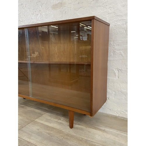 42 - A mid 20th century Avalon teak bookcase with two glass sliding doors - approx. 76cm high x 114cm wid... 