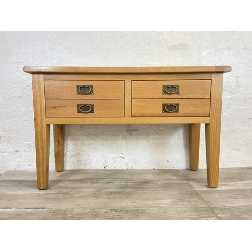 42A - A modern oak four drawer console table - approx. 75cm high x 120cm wide x 40cm deep