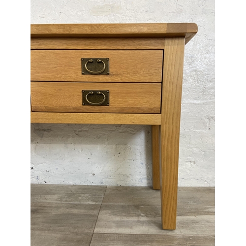 42A - A modern oak four drawer console table - approx. 75cm high x 120cm wide x 40cm deep