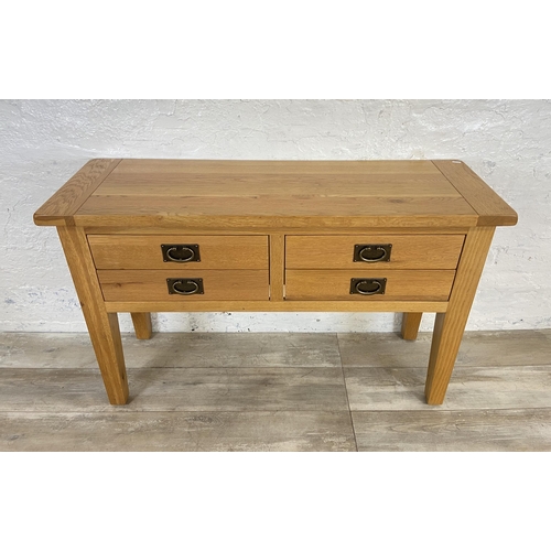 42A - A modern oak four drawer console table - approx. 75cm high x 120cm wide x 40cm deep