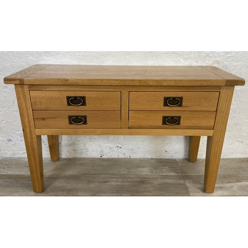 42A - A modern oak four drawer console table - approx. 75cm high x 120cm wide x 40cm deep