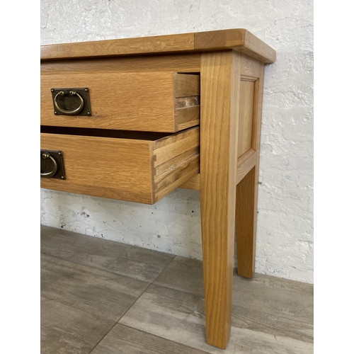 42A - A modern oak four drawer console table - approx. 75cm high x 120cm wide x 40cm deep