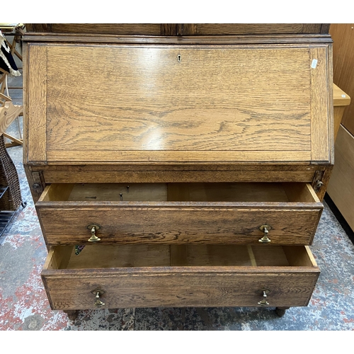 42B - An early 20th century oak bureau bookcase with two stained and leaded glass doors - approx. 198cm hi... 