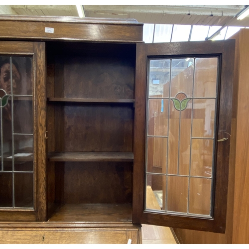 42B - An early 20th century oak bureau bookcase with two stained and leaded glass doors - approx. 198cm hi... 