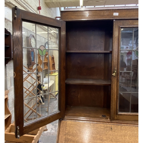 42B - An early 20th century oak bureau bookcase with two stained and leaded glass doors - approx. 198cm hi... 