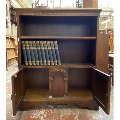 42D - A carved oak two tier bookcase containing Ten Volumes of The New Book of Knowledge - 103cm high x 84... 