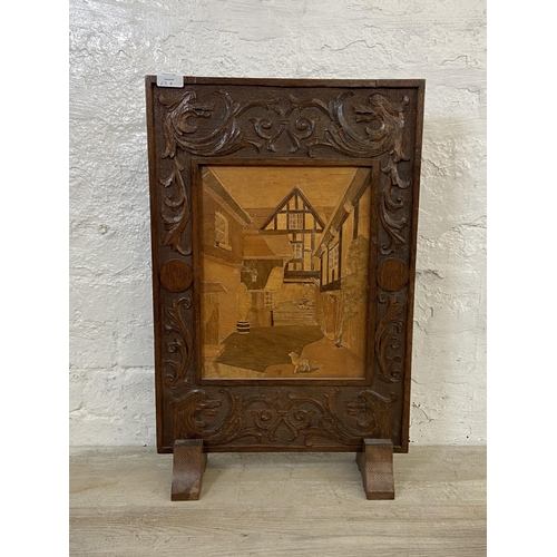 63A - An early 20th century carved oak and marquetry inlaid fire screen - approx. 65cm high x 42cm wide