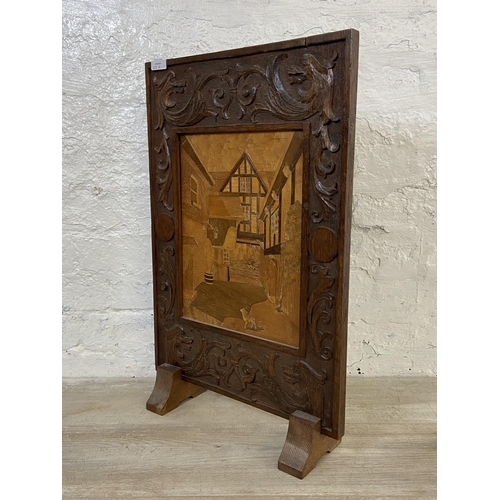 63A - An early 20th century carved oak and marquetry inlaid fire screen - approx. 65cm high x 42cm wide