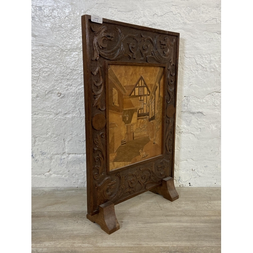 63A - An early 20th century carved oak and marquetry inlaid fire screen - approx. 65cm high x 42cm wide