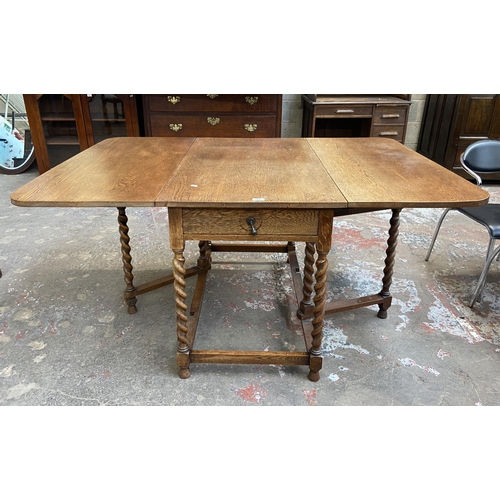 63C - An early 20th century oak drop leaf gate leg dining table on barley twist supports and four 19th cen... 