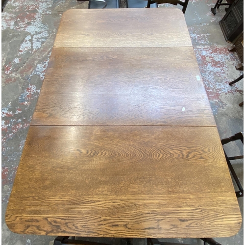 63C - An early 20th century oak drop leaf gate leg dining table on barley twist supports and four 19th cen... 