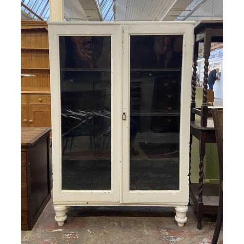 66 - An early 20th century white painted two door glazed bookcase - approx. 140cm high x 95cm wide x 30cm... 