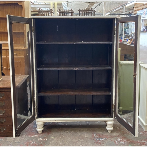 66 - An early 20th century white painted two door glazed bookcase - approx. 140cm high x 95cm wide x 30cm... 