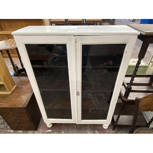 66 - An early 20th century white painted two door glazed bookcase - approx. 140cm high x 95cm wide x 30cm... 